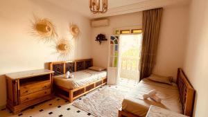 a bedroom with two beds and a window and a room with two beds at Dar Joud in Gabès +20 photos