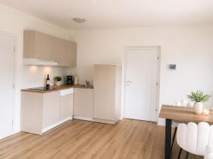 a kitchen with white cabinets and a wooden floor at Apartment Torggl Alpenblick in Coldrano