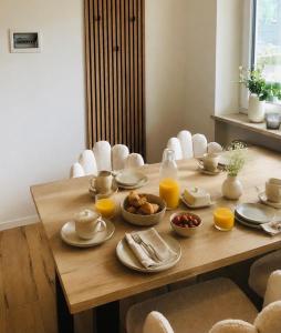 a wooden table with plates of food and orange juice at Apartment Torggl Alpenblick in Coldrano