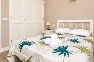 a bedroom with a white bed with palm trees on it at La Casita del Sur, Abades in Abades
