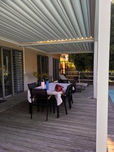 a patio with a table and chairs on a deck at Tahiti Green Lodge in Punaauia