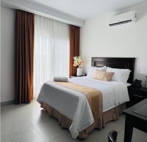 a bedroom with a large bed and a window at Hotel Fénix in Santa Rosa de Copán