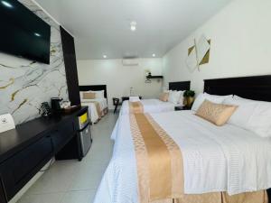 a hotel room with two beds and a flat screen tv at Hotel Fénix in Santa Rosa de Copán