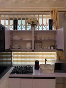 a kitchen with white cabinets and a stove top oven at Nyaniba Villa in Accra