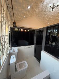 a bathroom with a toilet and a sink at Nyaniba Villa in Accra +7 photos