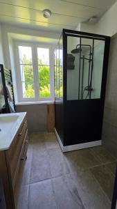 a bathroom with a shower with a black door at Le Relais de Saint Germain in Saint-Germain-les-Belles