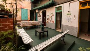 a room with two benches and a table on a building at A la Gurda Hostel - Barrio Norte in San Miguel de Tucumán