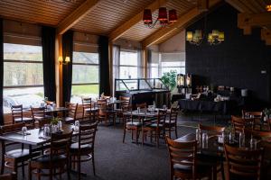 a restaurant with tables and chairs and a piano at Ørnes Hotell in Ørnes