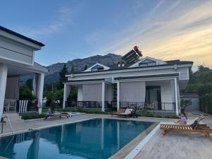 a house with a swimming pool and a house at minta suits in Kemer