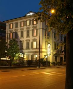 un edificio blanco con un letrero iluminado delante de él en Hotel Residence, en Parma