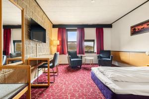 a hotel room with a bed and a desk and chairs at Ørnes Hotell in Ørnes