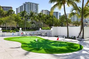 a miniature golf course in a courtyard with palm trees at King Suite at Ocean Blvd in Fort Lauderdale