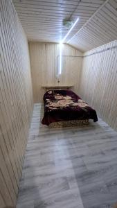 a small room with a bed in a wooden wall at Байк Пост Т67 in Voznesensk