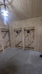 a room with three wooden doors in a barn at Байк Пост Т67 in Voznesensk +1 photo