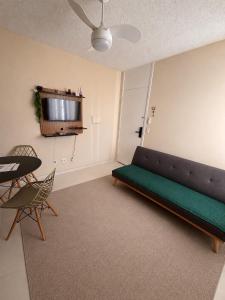 a living room with a couch and a table and a television at Apartamento 2 quartos ,Mobiliado em Sumare SP in Sumaré