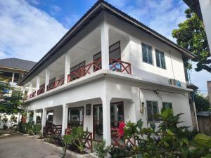 a white house with a balcony on top of it at ROHO-Residence in Nungwi