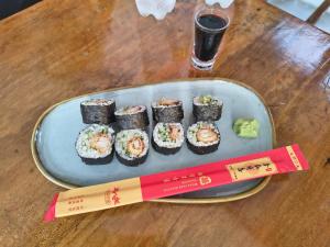 a plate of sushi on a table with a chopstick at ROHO-Residence in Nungwi