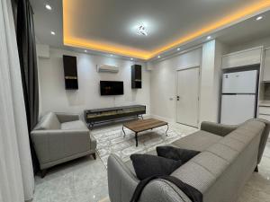 a living room with a couch and a tv at minta suits in Kemer