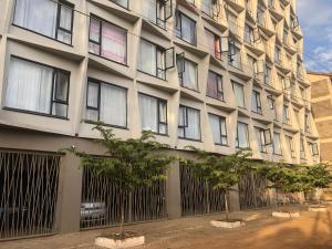 a building with windows and trees in front of it at Tsavo Stanley, Kiambu La Mayan in Kiambu