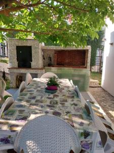 a table with chairs and a television on a patio at Vila PANORAMA in Karianí +7 photos
