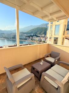 a balcony with chairs and tables and a view of a city at Panorama Chill in Rafailovici