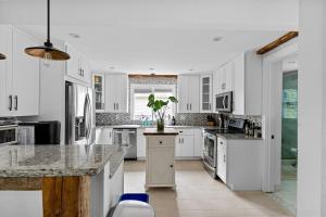 a kitchen with white cabinets and a potted plant on the counter at Cozy Greenport Cottage in Greenport