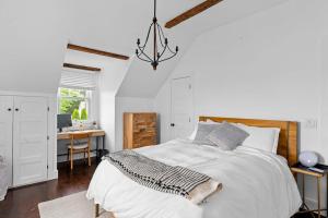 a white bedroom with a bed and a desk at Cozy Greenport Cottage in Greenport