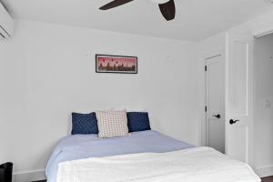 a bedroom with a bed with a ceiling fan at Cozy Greenport Cottage in Greenport