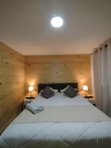 a bedroom with a large white bed with two lamps at Casa Marina Sotomayor in Santiago