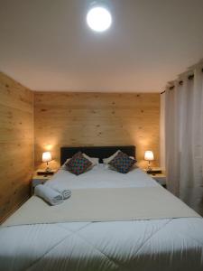 a bedroom with a large white bed with two lamps at Casa Marina Sotomayor in Santiago