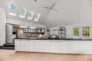 a large kitchen with white cabinets and a ceiling fan at Southampton Beauty in Southampton +22 photos
