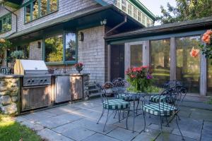 a patio with a table and chairs and a grill at Cedar Crest Retreat in Southampton