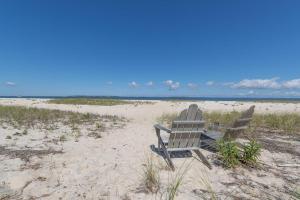 two chairs sitting in the sand on a beach at Cedar Crest Retreat in Southampton