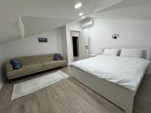 a white bedroom with a bed and a couch at minta suits in Kemer +11 photos