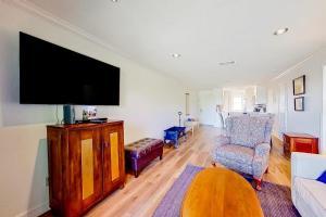 a living room with a flat screen tv and a chair at Tranquility on the Lake in Montgomery