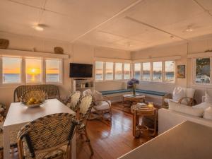 a living room with a couch and a table at Beachfront Bliss - Stay Waiheke in Onetangi
