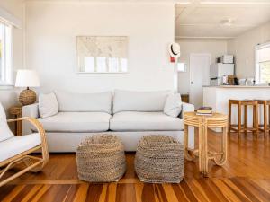 a living room with a couch and a table at Beachfront Bliss - Stay Waiheke in Onetangi +11 photos