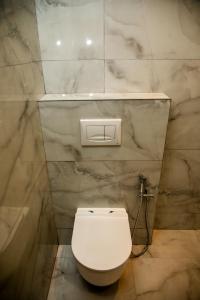 a bathroom with a white toilet and a bath tub at HOTEL CENTERPOINT Tirana in Tirana