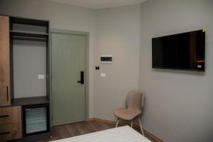 a room with a bed and a chair and a television at HOTEL CENTERPOINT Tirana in Tirana +22 photos