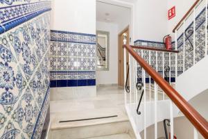 a staircase in a home with blue and white tiles at Hostal Colón Don Miguel in Cádiz