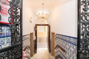 a hallway with a door with a chandelier at Hostal Colón Don Miguel in Cádiz