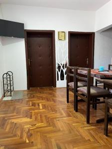 a dining room with wooden floors and a table and chairs at Amos 1 in Paraćin