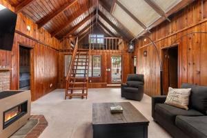 ein Wohnzimmer mit Kamin und Holzwand in der Unterkunft Tree Canopy Oasis in East Quogue