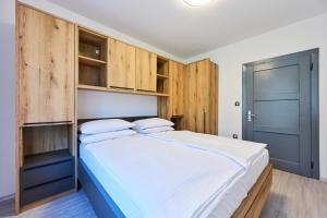 a bedroom with a large bed with wooden cabinets at Luče Holiday Apartment in Luče