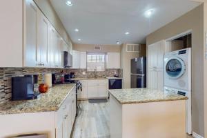 a large kitchen with white cabinets and a washer and dryer at Mariner Village 108 in Seabrook +16 photos