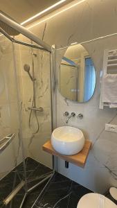 a bathroom with a sink and a shower with a mirror at Experience Hotel Antico Capon in Venice