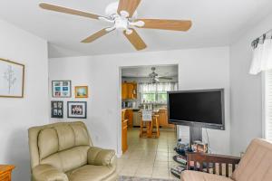a living room with a ceiling fan and a flat screen tv at Minnehaha Marvel in Southold
