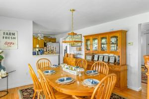 a dining room with a wooden table and chairs at Minnehaha Marvel in Southold +17 photos