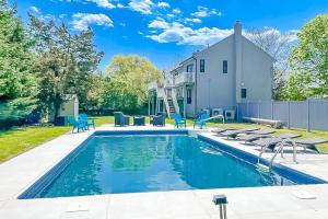 ein Swimmingpool vor einem Haus mit einem Haus in der Unterkunft Marble & Sun in Hampton Bays