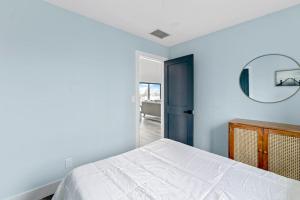 ein Schlafzimmer mit einem weißen Bett und einem Spiegel in der Unterkunft Marble & Sun in Hampton Bays